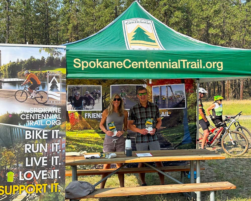Friends-Of-The-Centenial-Trail-Spokane-AboutPhoto4 Friends of the Centennial Trail volunteers hosting an outdoor booth to support and promote the Spokane River Centennial Trail